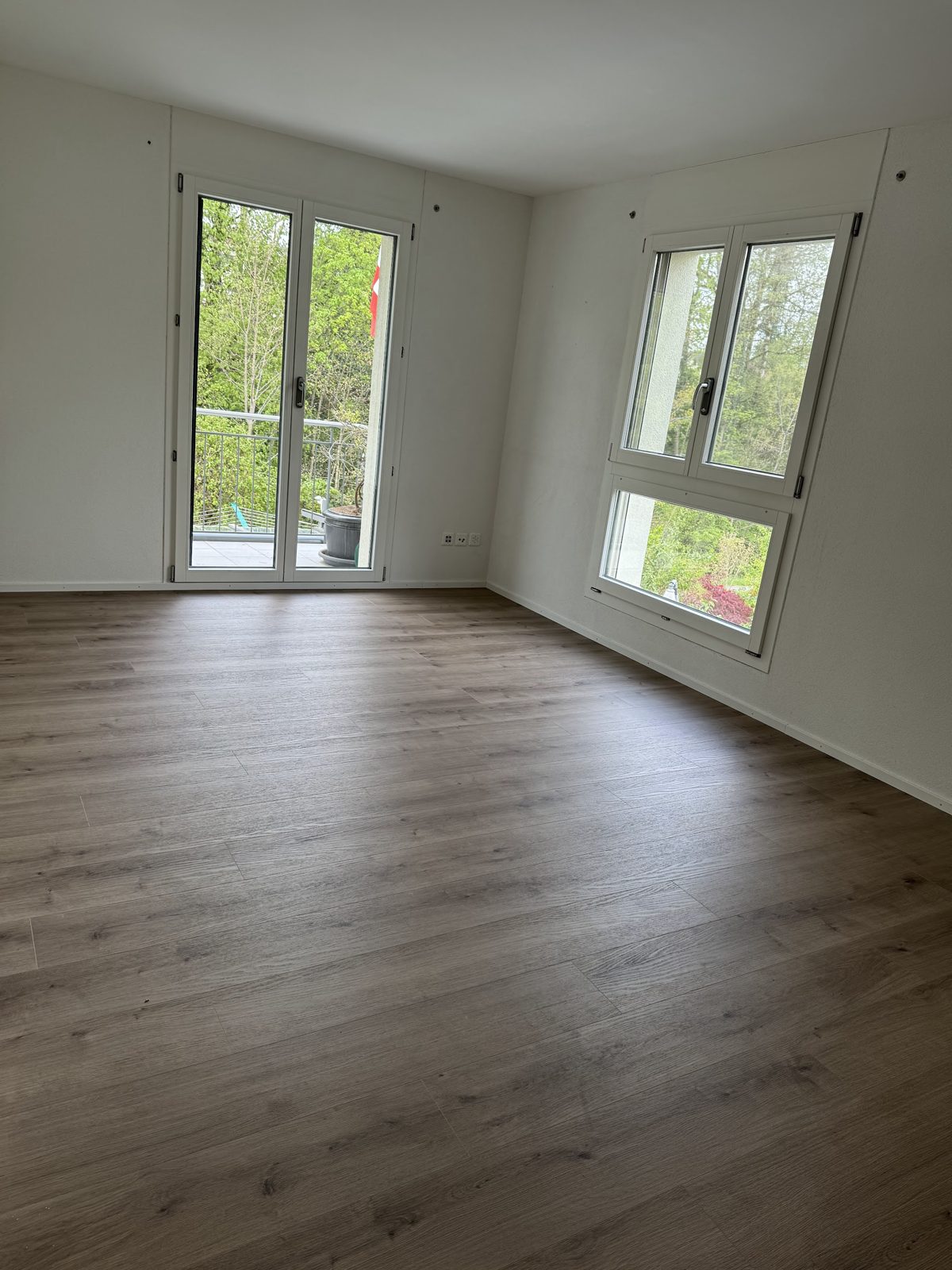 Leerer Raum mit neu verlegtem Bodenbelag in Holzoptik