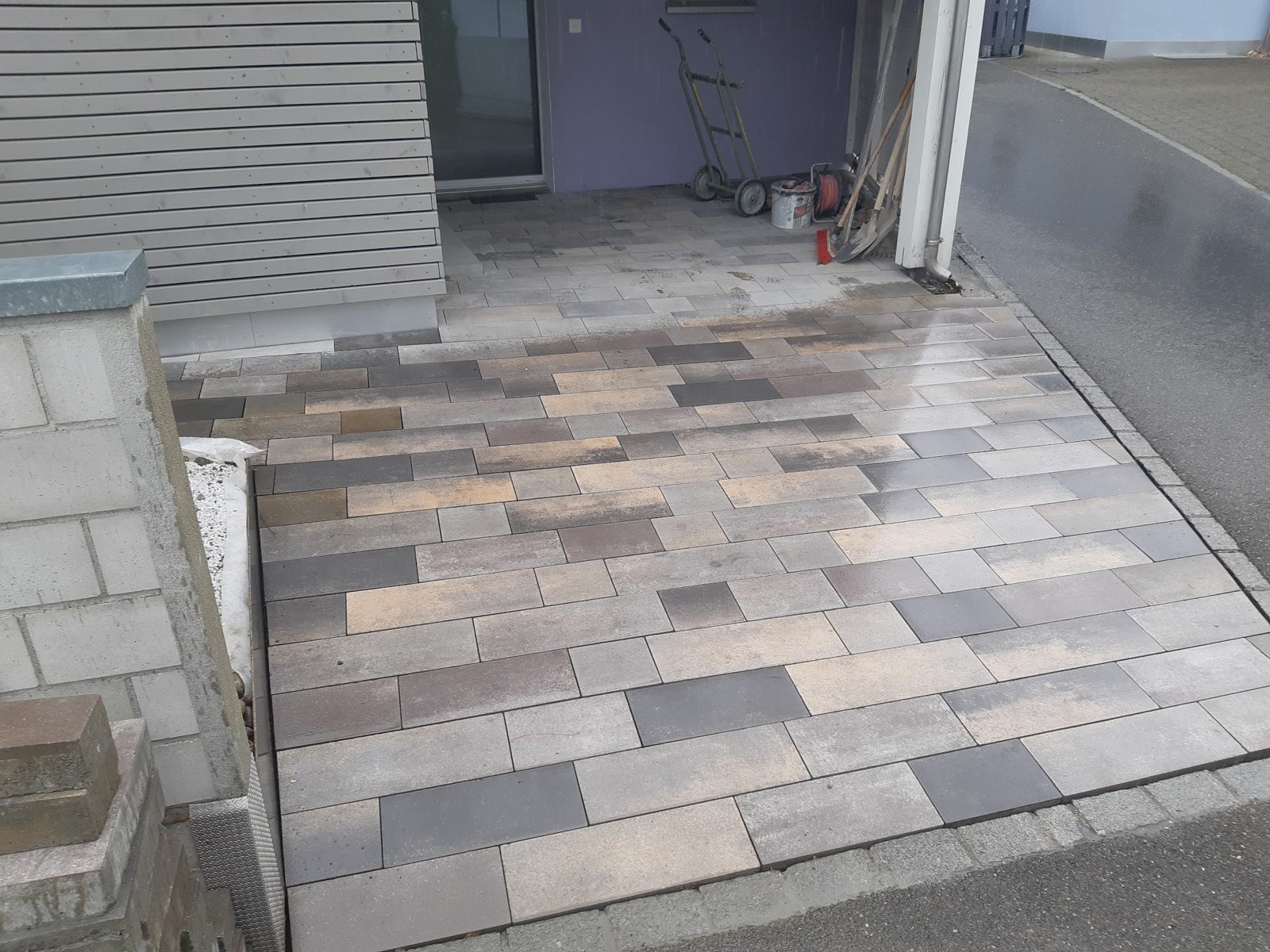 Vorplatz mit mehrfarbigen Betonplatten im Verband verlegt