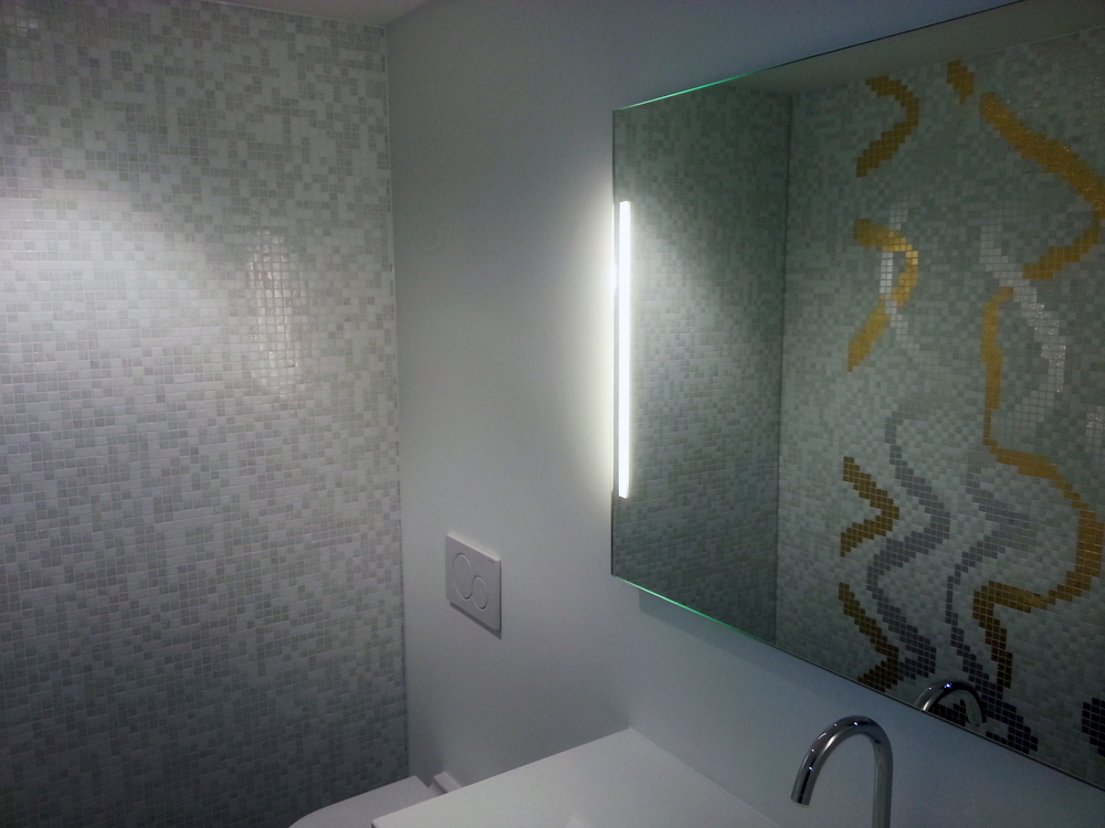 Badezimmer mit Mosaikwand und grossem Spiegel
