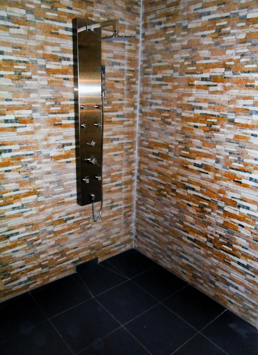 Dusche mit Natursteinriemchen und Edelstahl-Duschpaneel
