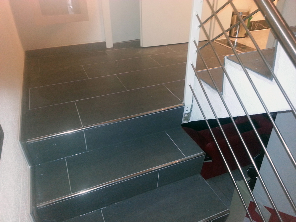 Treppe mit grauen Grossformatplatten und Kantenprofil aus Metall