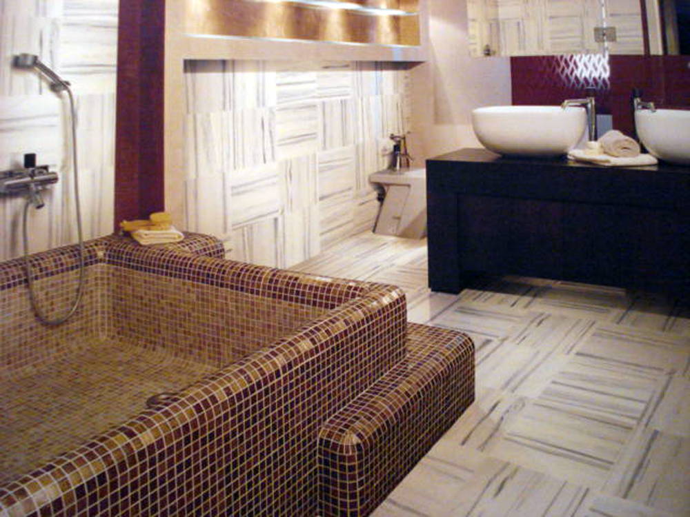 Wellness-Bad mit Mosaik-Badewanne und Marmorboden